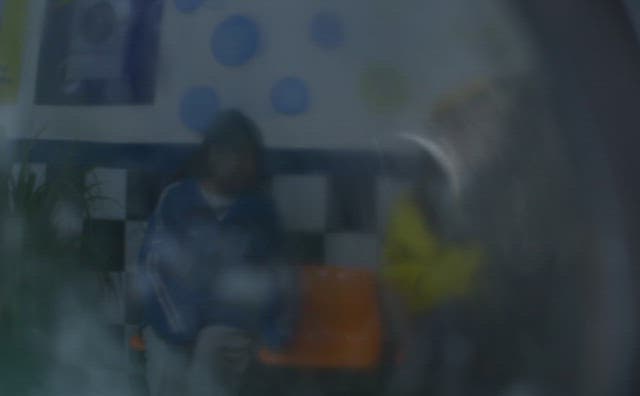 Woman reflected in the glass door of a running washing machine