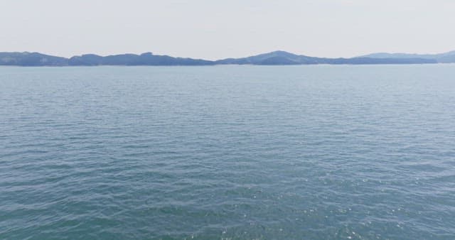 Calm sea with distant mountains