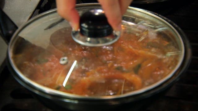 Spicy braised sand eels being cooked in a pan in the kitchen