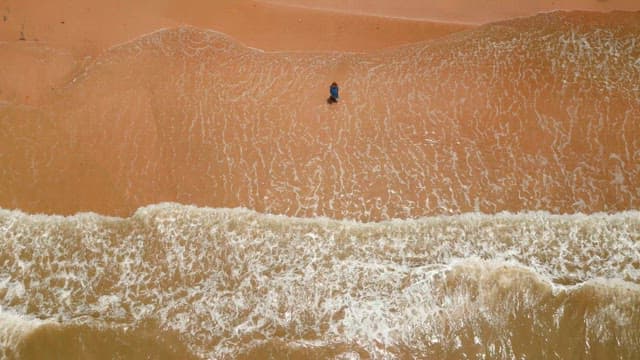 Person walking along a sandy beach