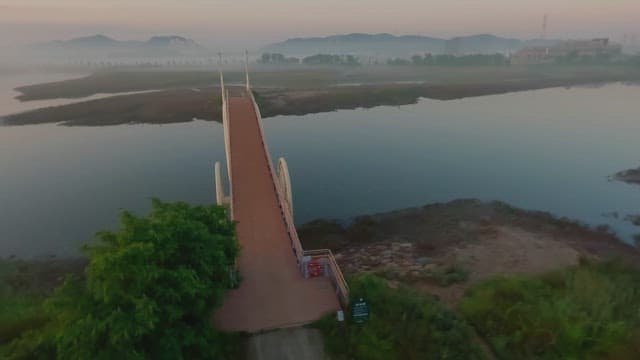 Serene bridge over a misty river at dawn