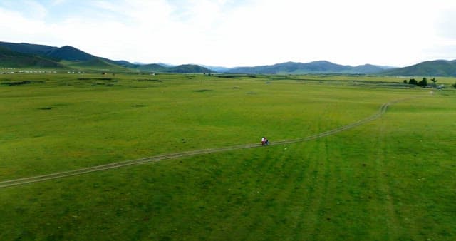 Motorcycle ride through vast green fields
