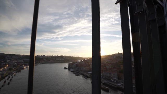 Early evening view of a river with a cityscape in the background through railings