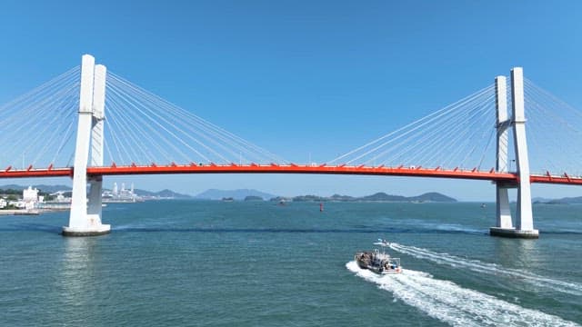 Boat passing under a red bridge