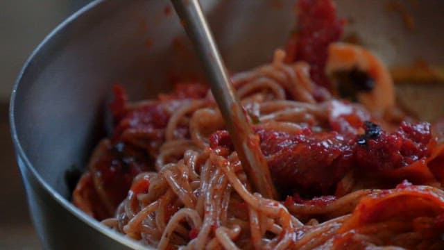 Spicy buckwheat noodles lifted with chopsticks