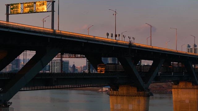 Train passing under a city bridge