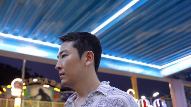 Man at an amusement park at night