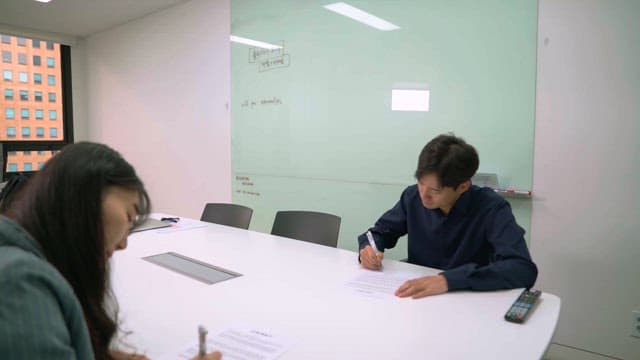 Two colleagues signing documents in the office