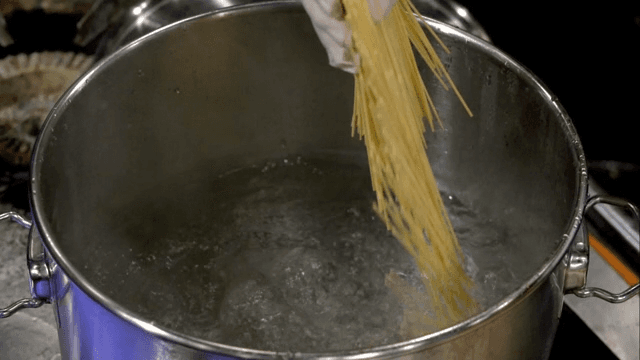 Yellow noodles being put in boiling water