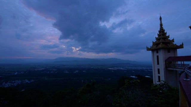 Structure of a Buddhist temple under a dark cloudy sky