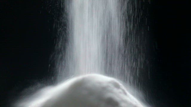 White lactobacillus powder falling on dark background