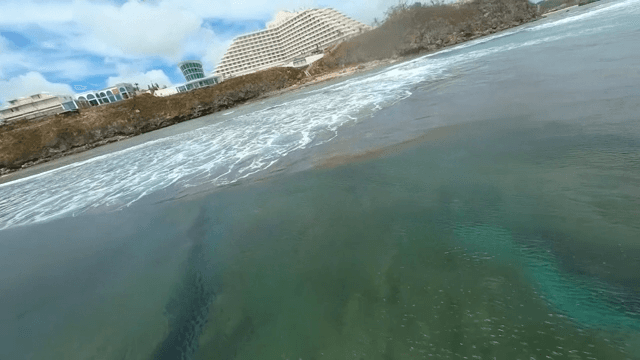Coastal view with surfers and buildings