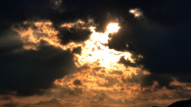 Sunlight breaking through dark clouds