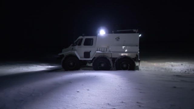Vehicle with Lights and a Landscape Full of Snow