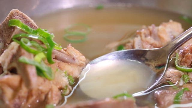 Spoonful of Korean beef bone soup with green onions