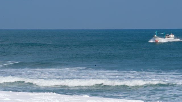 Boat sailing across the blue ocean on a bright day