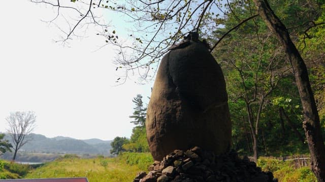 Rock tower surrounded by trees and greenery