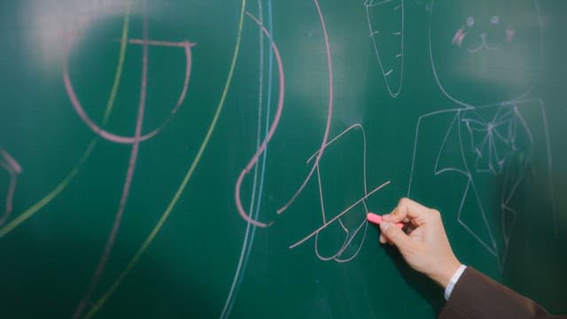 Student scribbling on a classroom blackboard