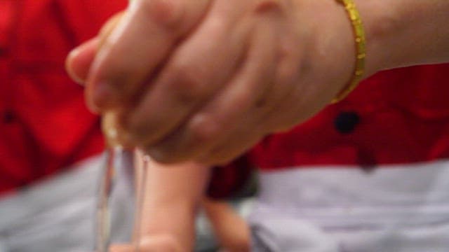 Cracking an egg into a boiling pot with fish cakes