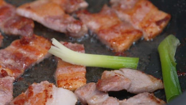 Grilling pork belly and green onion in a pan