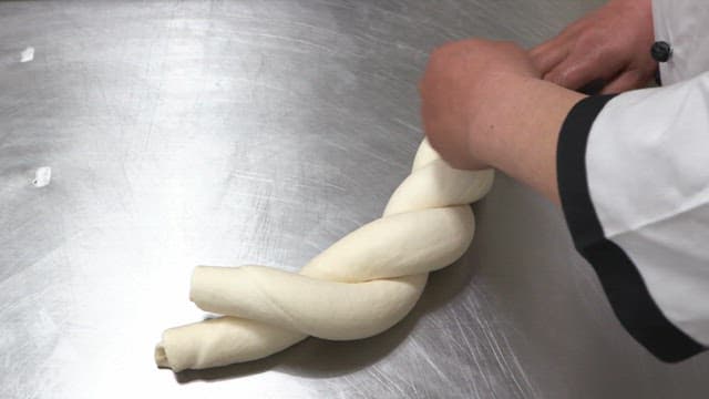 Chef twists dough into a twist shape