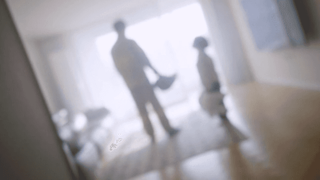 Firefighter and child standing side by side in a bright living room