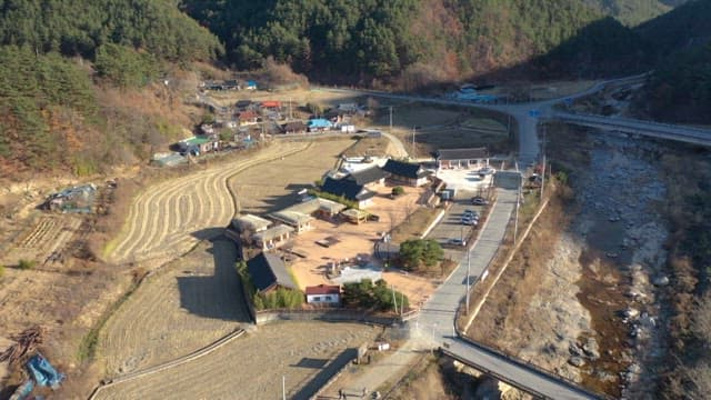 Traditional Korean Houses in a Mountain Village Next to a Stream and Farmland