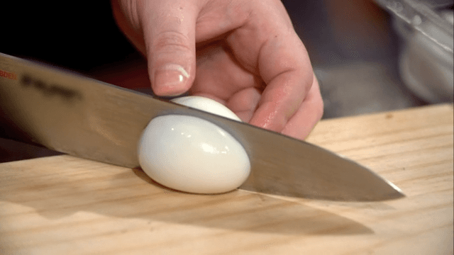 Slicing a peeled boiled egg