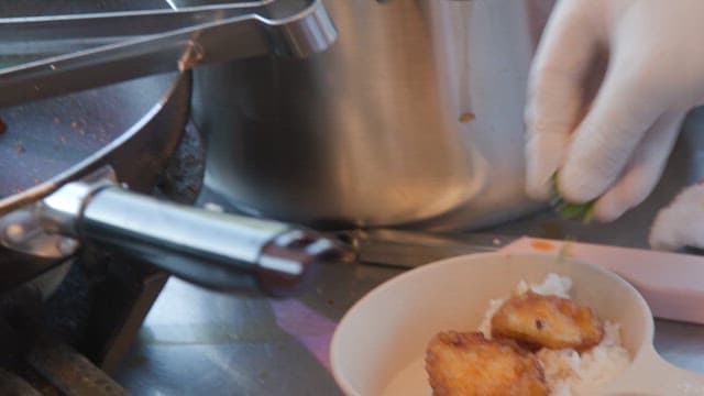 Sprinkle green onions and sauce powder on top of rice with fried fish