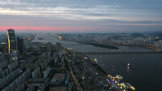 Twilight Cityscape with Illuminated Bridge and River