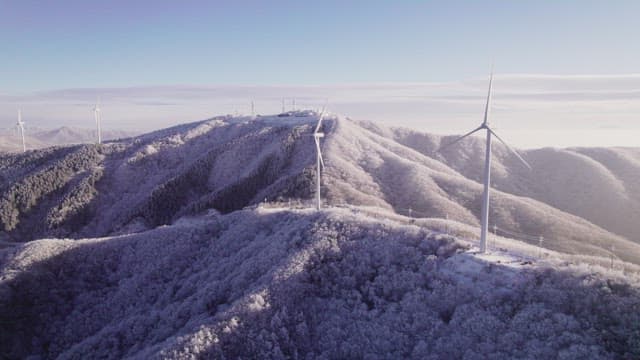 Wind Generators on Misty and Snowy Mountain in the Morning