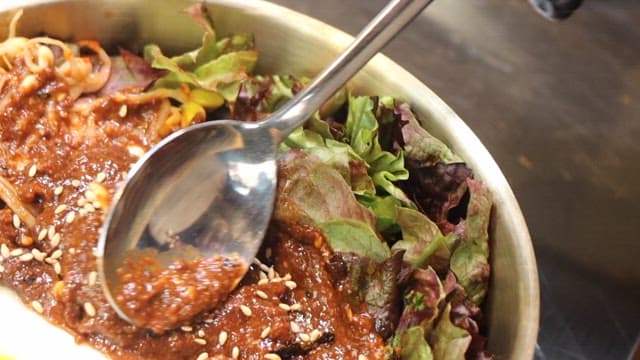 Mixing traditional Korean bibimbap in bowl