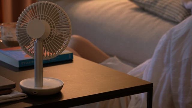 Portable fan on a bedside table