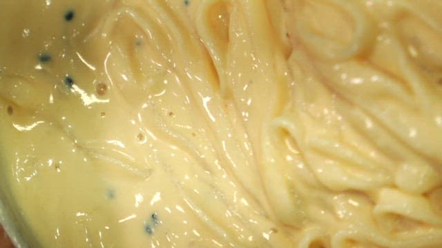 Stirring savory noodles in cold soybean soup with chopsticks