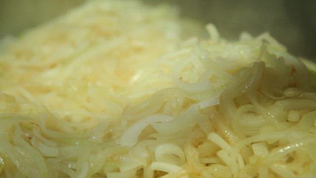 Onions being sautéed on a hot griddle