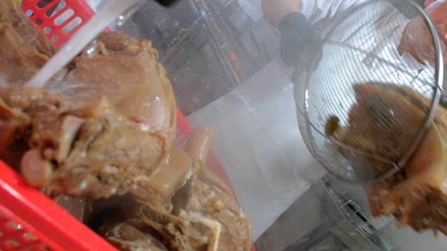 Rinsing boiled pig's feet and meat in water in the kitchen
