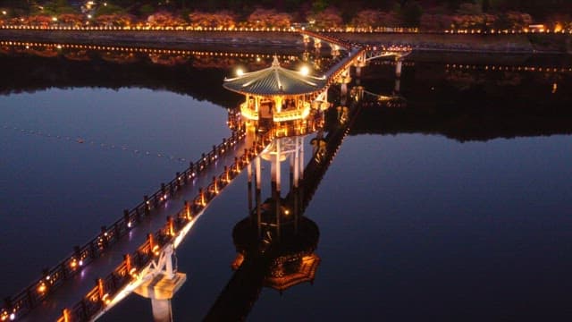 Illuminated pavilion on a serene river at night