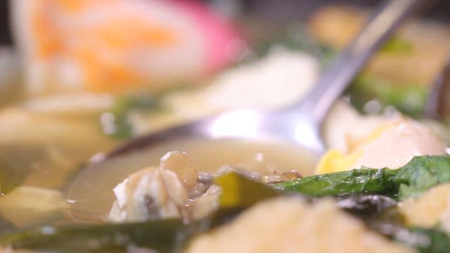 Spoonful of oysters lifted from the warm broth