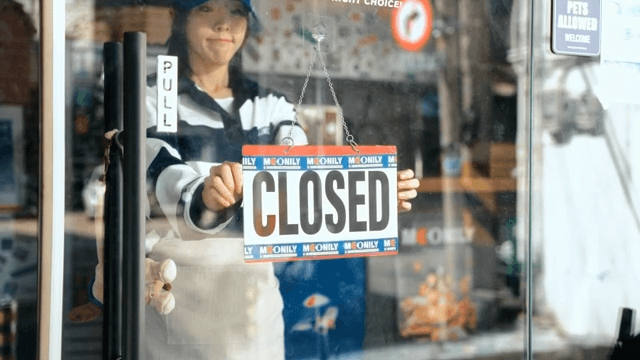 Woman turns pizza shop sign to announce closure