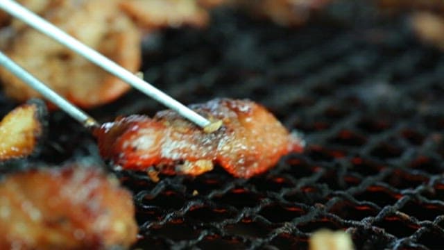 Well-cooked marinated galbi picked up with chopsticks