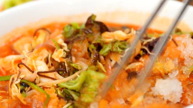 Stirring cold raw fish soup with chopsticks