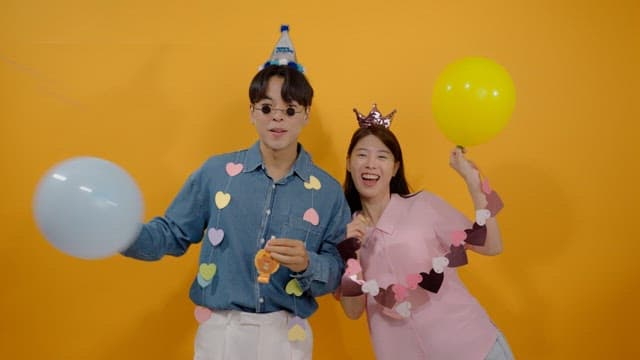 Two happy people celebrating with balloons