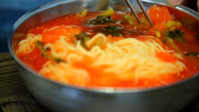 Stirring yeolmu noodles with chopsticks