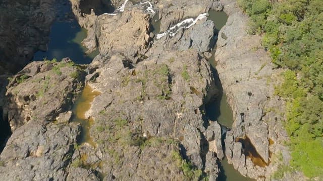 Aerial view of a cascading Barron Falls on a rocky cliff
