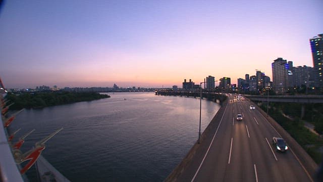 Dusk Cityscape with Lit Highways by River