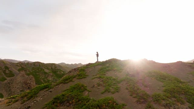 Person standing on a mountain in the sunlight