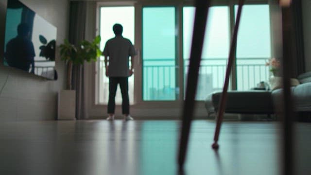 Back of a Lonely Man Standing by the Apartment Window