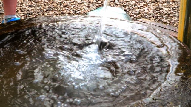 Clear, cool water coming from a pump in pebble-lined mineeral pump