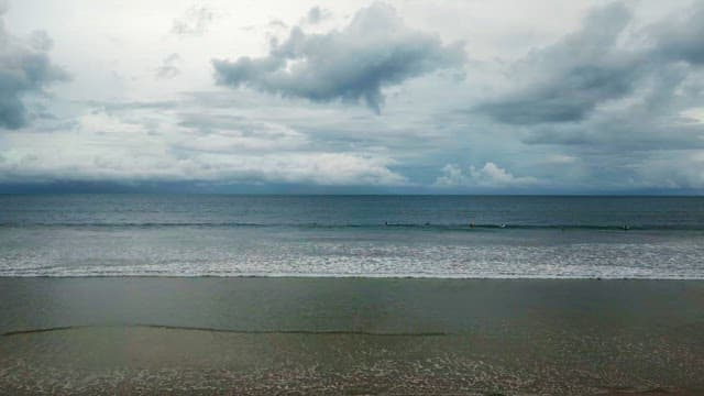 Surfers waiting on a cloudy beach