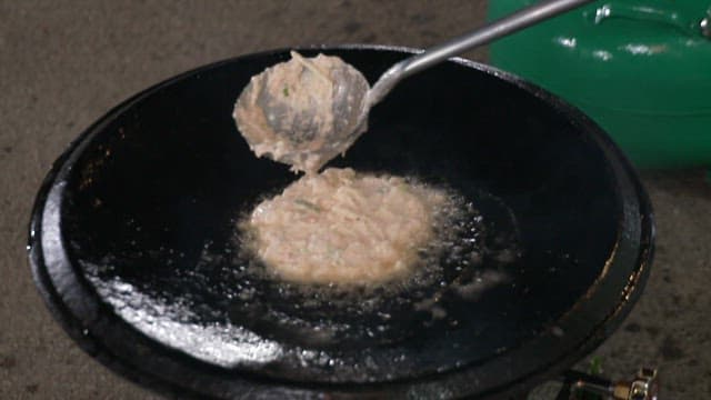 Batter of pancake sizzling on a hot, oiled pan